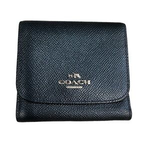 Navy leather Coach trifold wallet with outside snap coin pocket.